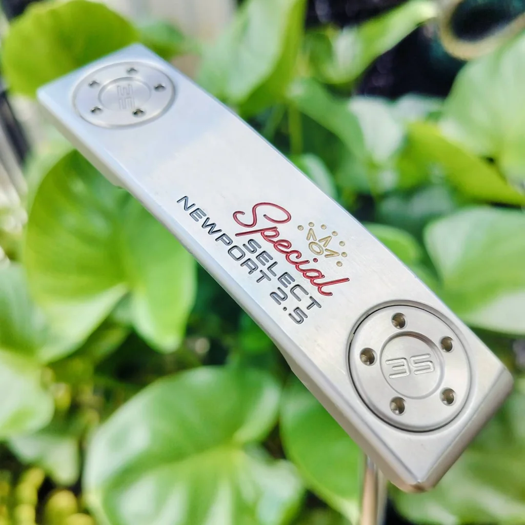 PUTTER SCOTTY CAMERON SPECIAL SELECT NEWPORT 2.5 ออกแบบโดยใช้สีแบบสเตนเลสดิบที่มีเอกลักษณ์ มีความสว่างที่โดดเด่น แต่ไม่สะท้อนแสง ด้านหลังพัตเตอร์ตกแต่งด้วยจุดสามจุดที่เป็นเอกลักษณ์ของ Scotty ไม้กอล์ฟพรีเมี่ยมมือสอง ของแท้ By NakaraLuxurious PUTTER SCOTTY CAMERON SPECIAL SELECT NEWPORT 2.5 ออกแบบโดยใช้สีแบบสเตนเลสดิบที่มีเอกลักษณ์ มีความสว่างที่โดดเด่น แต่ไม่สะท้อนแสง ด้านหลังพัตเตอร์ตกแต่งด้วยจุดสามจุดที่เป็นเอกลักษณ์ของ Scotty ไม้กอล์ฟพรีเมี่ยมมือสอง ของแท้ By NakaraLuxurious