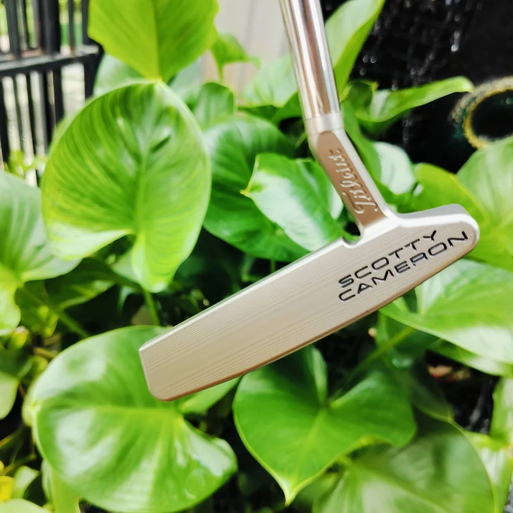 PUTTER SCOTTY CAMERON SPECIAL SELECT NEWPORT 2.5 ออกแบบโดยใช้สีแบบสเตนเลสดิบที่มีเอกลักษณ์ มีความสว่างที่โดดเด่น แต่ไม่สะท้อนแสง ด้านหลังพัตเตอร์ตกแต่งด้วยจุดสามจุดที่เป็นเอกลักษณ์ของ Scotty ไม้กอล์ฟพรีเมี่ยมมือสอง ของแท้ By NakaraLuxurious PUTTER SCOTTY CAMERON SPECIAL SELECT NEWPORT 2.5 ออกแบบโดยใช้สีแบบสเตนเลสดิบที่มีเอกลักษณ์ มีความสว่างที่โดดเด่น แต่ไม่สะท้อนแสง ด้านหลังพัตเตอร์ตกแต่งด้วยจุดสามจุดที่เป็นเอกลักษณ์ของ Scotty ไม้กอล์ฟพรีเมี่ยมมือสอง ของแท้ By NakaraLuxurious